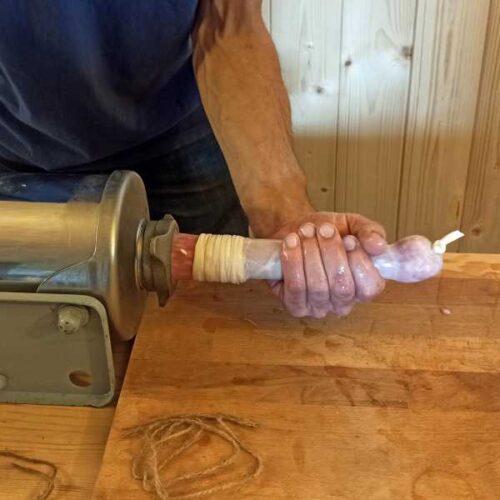 Die Rindswurst in Därme füllen.