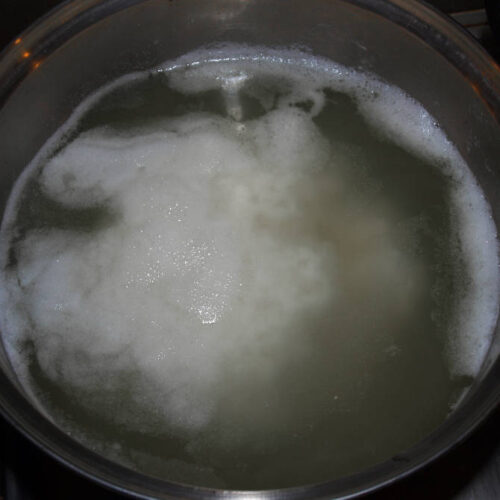 Flocken die sich im Topf abgesetzt haben um Paneer Käse zu machen.