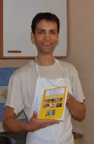 Der Autor mit dem Buch Wurst selber machen in der Hand.